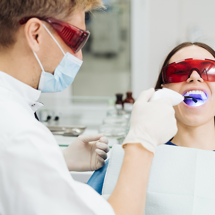 woman receiving professional teeth whitening treatment at dental clinic